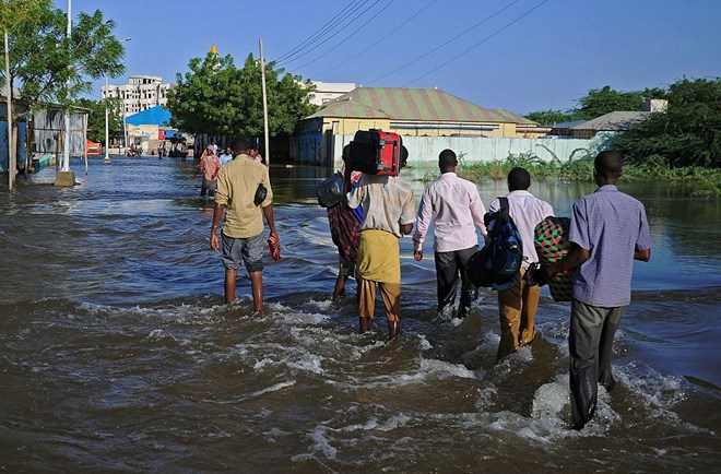 Residents walk through flooded streets in Beledweyne, north of Mogadishu on May 26, 2016. / AFP / MOHAMED ABDIWAHAB